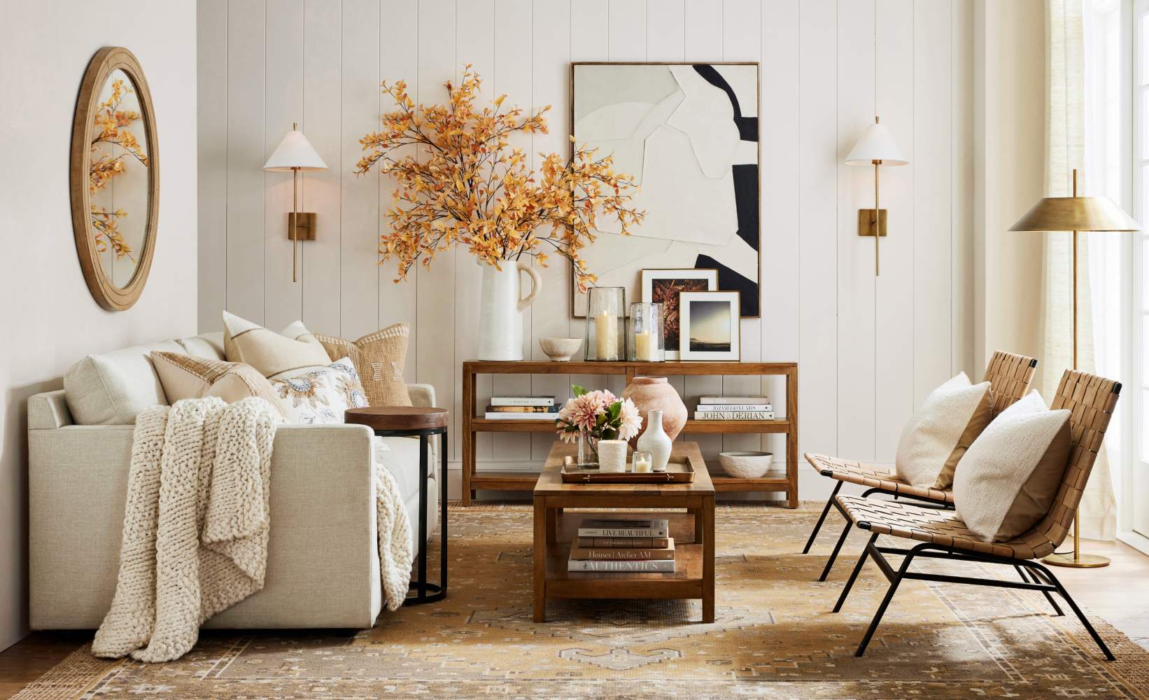 Modern, cozy living room featuring a light beige sofa with a knitted throw blanket and accent pillows.
