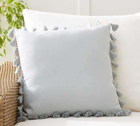 white pillow with colorful tassels