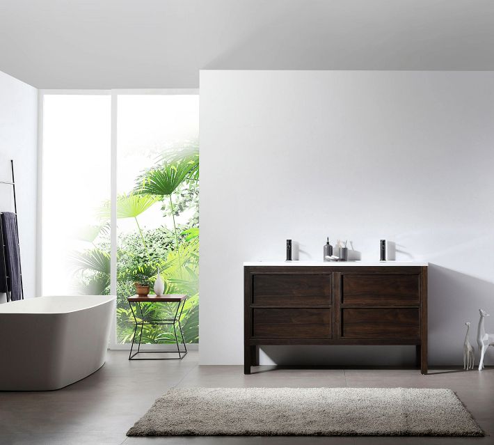 A modern bathroom vanity with white countertop, two sinks, dark wood cabinet and black faucets; minimal bathroom setting with bathtub and plants.
