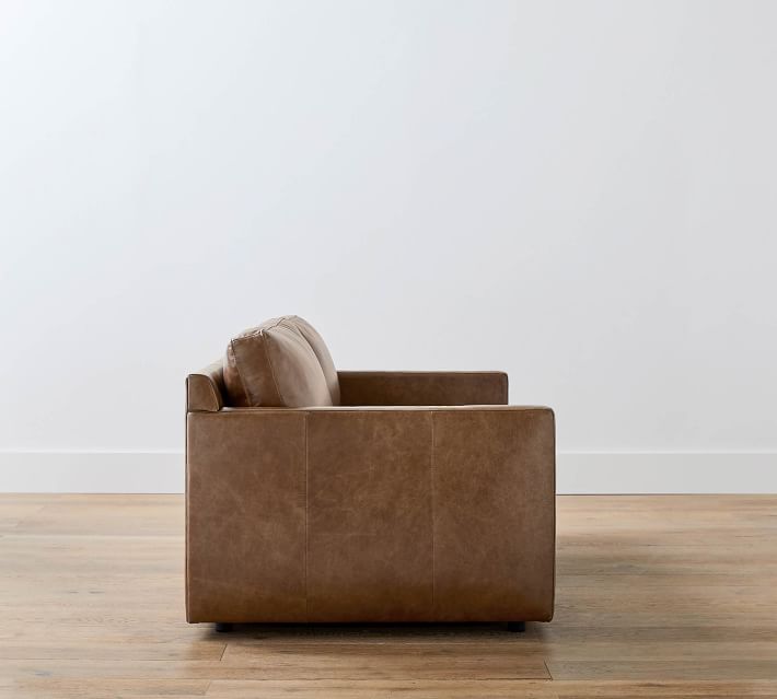 Side view of brown leather sofa showing armrest and cushions