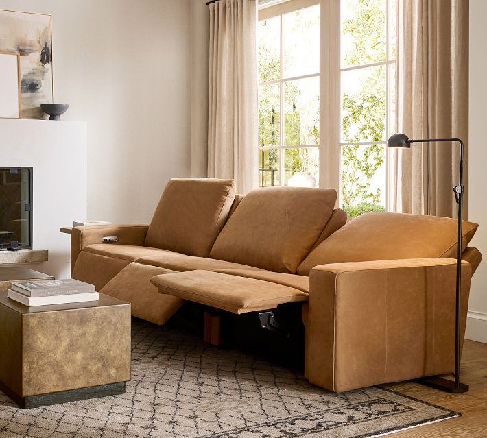 Interior shot of tan leather sofa in living room with decorative items.
