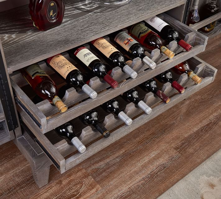 Open drawers and multiple wine bottles stored in a cabinet with an integrated bottle rack.