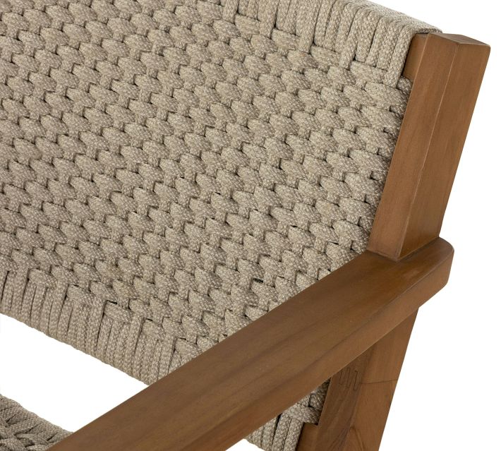 Close-up of woven seat and wooden armrest junction on chair