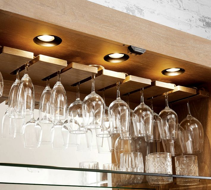 Under-cabinet glassware hanging from inverted racks with built-in spotlights.
