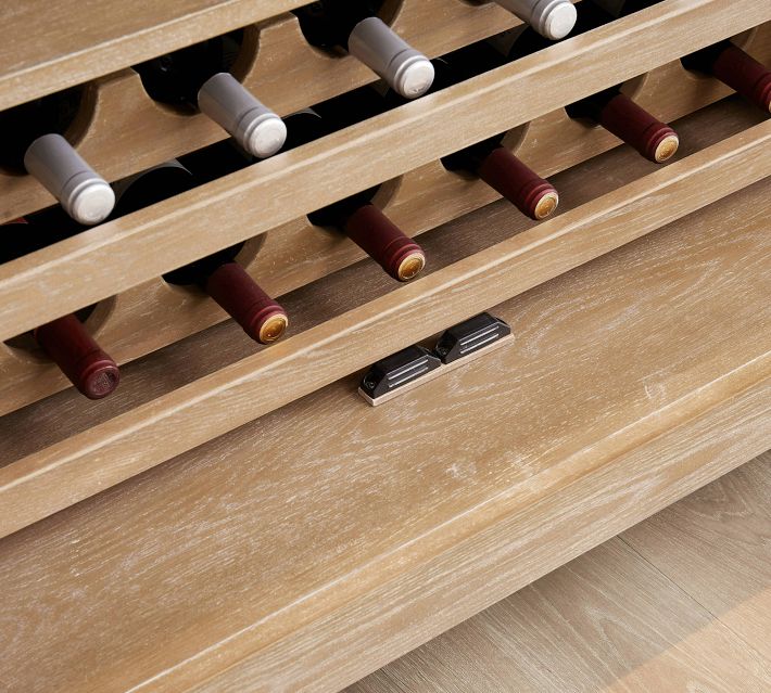 Close-up of wine bottles in a rack with bottle stoppers visible.