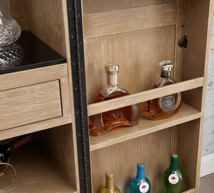 Two bottles on wooden shelves inside a cabinet.
