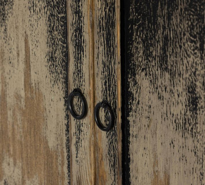 Corner of the cabinet showing distressed two-tone wood with circular handles.