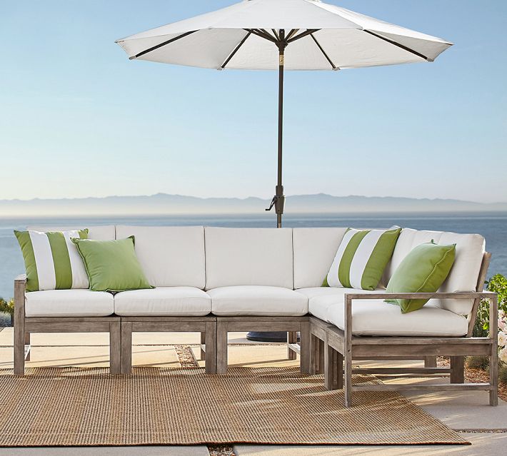 Outdoor sectional with canopy or umbrella and cushions on deck by water