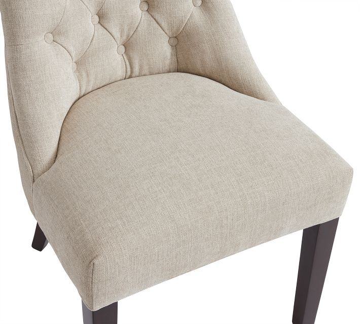 Close-up of beige tufted dining chair seat and back with visible fabric texture