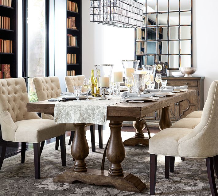 Elegant dining table set with glassware, candles, and plates in a modern dining room