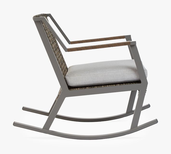 Side profile of a single outdoor wicker rocking chair showing armrest and cushion