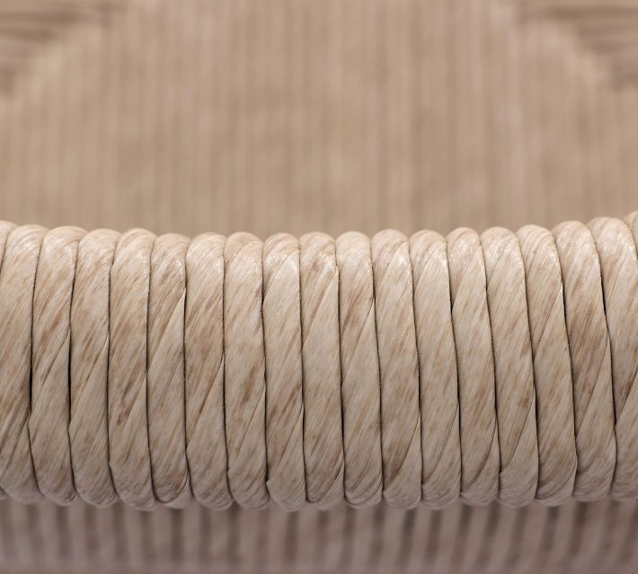 Close-up of tightly wound beige rope used for seating on furniture.