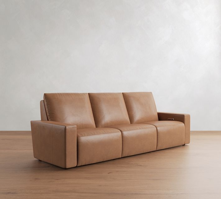 Three-seat tan leather sofa with one long armrest, side view highlighting armrest and seat cushions.
