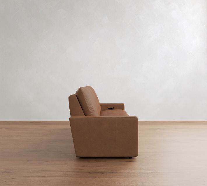 Back view of a tan leather sectional sofa showing three rear cushions and seating arrangement.