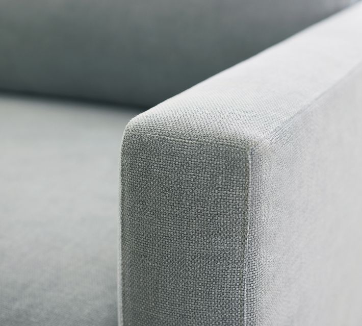 Close-up of light grey fabric texture on sofa arm