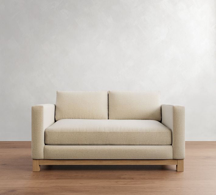 Beige two-seat sofa with wooden legs on wooden floor