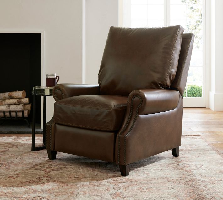 A brown leather recliner chair in a living room setting with a side table and a fireplace; the chair appears fully assembled and in a seating position