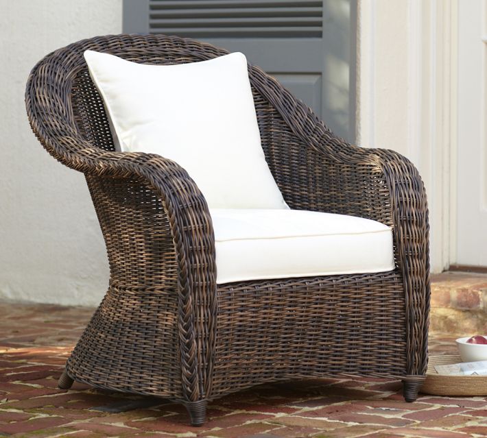 Brown wicker lounge chair with white cushions