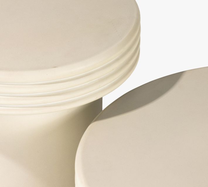 Two ribbed-edge circular tabletops stacked with cylindrical pedestal bases.
