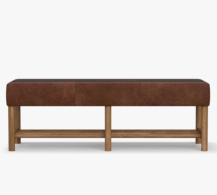 A long rectangular bench with brown leather seat and a two-tone wood frame; it appears to be a storage/ottoman with open shelf underneath.