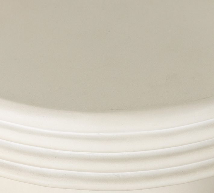 Close-up of the edge detail on a cream pedestal table showing layered rings.