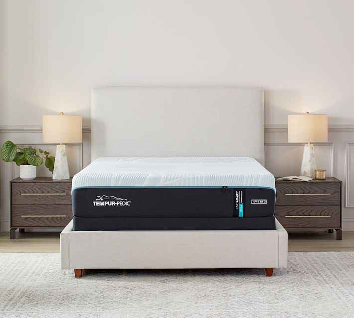 Close-up of a Tempur-Pedic mattress with white top and black sides, showing brand logo on the side.