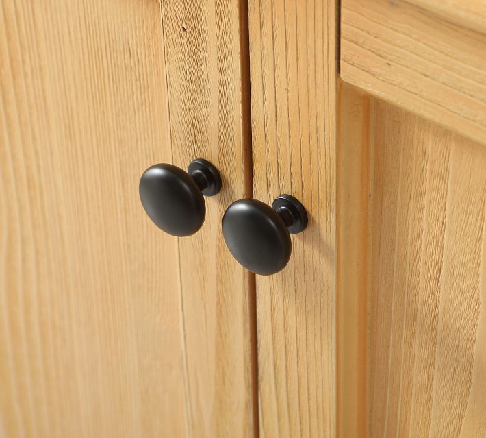 Close-up of wood grain and cabinet knob on light wood cabinetry.