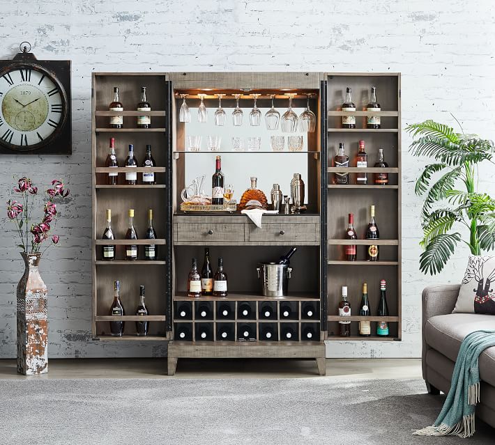 A large rustic cabinet opened to show glassware on the top shelves, bottles on the side shelves, a central mirrored bar area, and a wine rack.