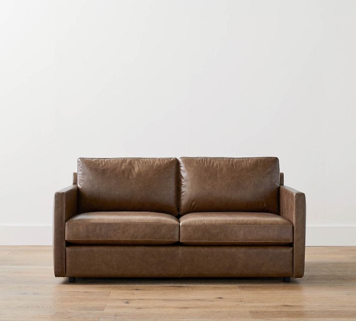 Brown leather sofa centered against white wall