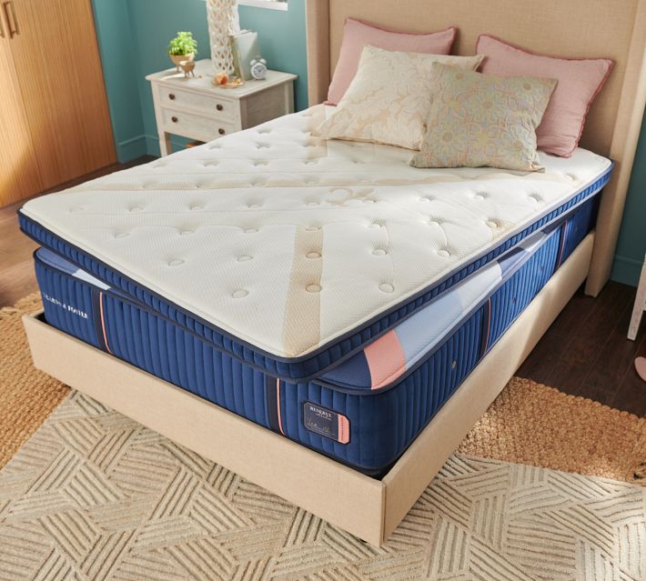 Uncovered mattress layers showing white top, blue inner layers, and coordinated bedding.