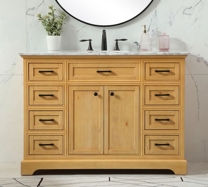 Natural wood vanity with marble top, multiple small drawers and cabinet doors, warm wood tone