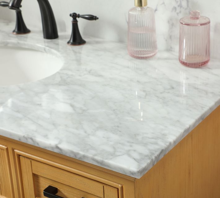 Close-up of pink glass containers on marble countertop