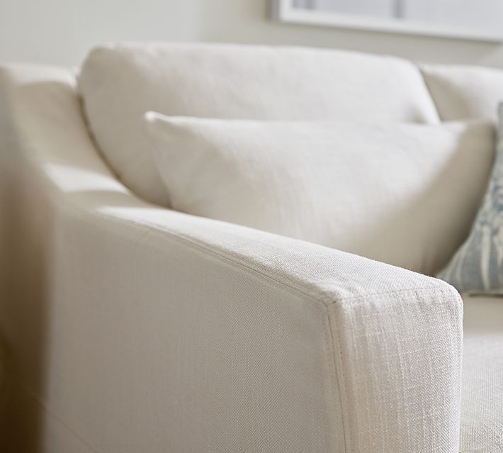 Close-up of sofa arm and cushion with soft fabric, beige color.