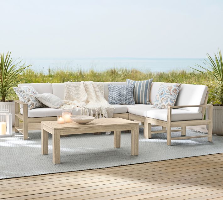 Set of outdoor seating area with sectional sofa and coffee table on rug