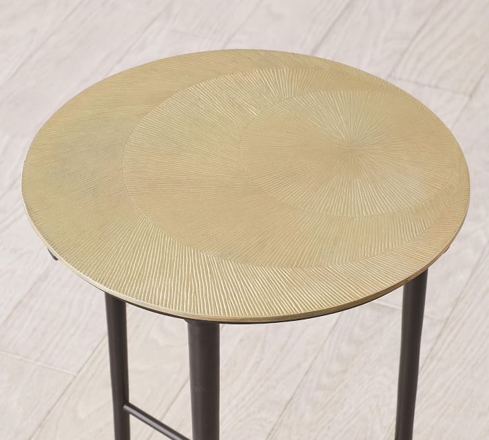 Round gold-colored textured table top on a metal stand