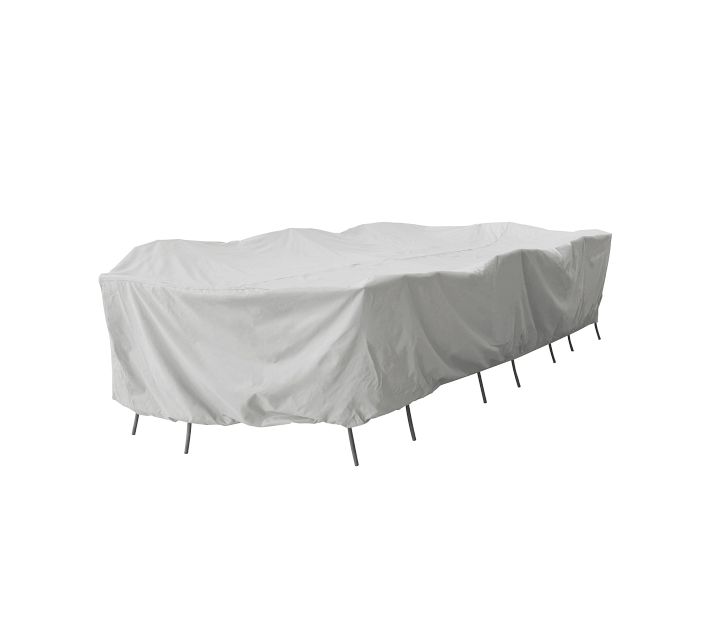 Long outdoor furniture piece covered with a light gray protective cover; multiple legs visible underneath