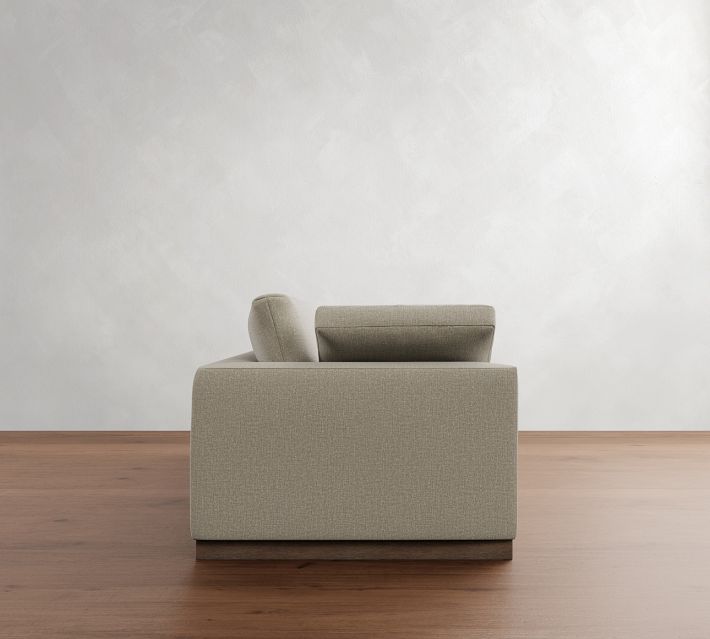  side view of beige fabric sofa showing armrest and cushions