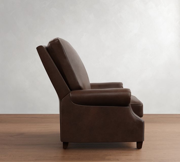 Side view of a brown leather recliner with footrest extended at right side; chair on wooden floor