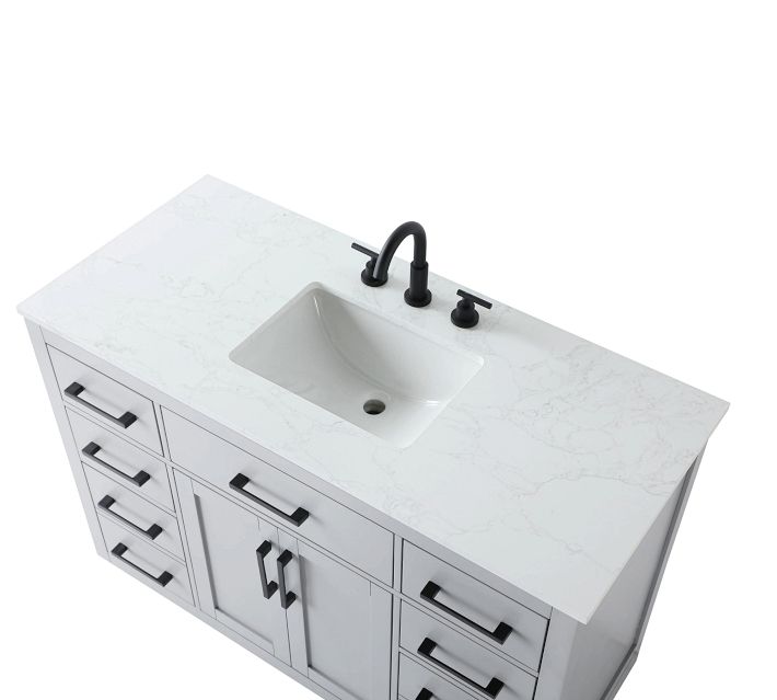 White marble countertop with integrated sink and black faucet and handles on either side.