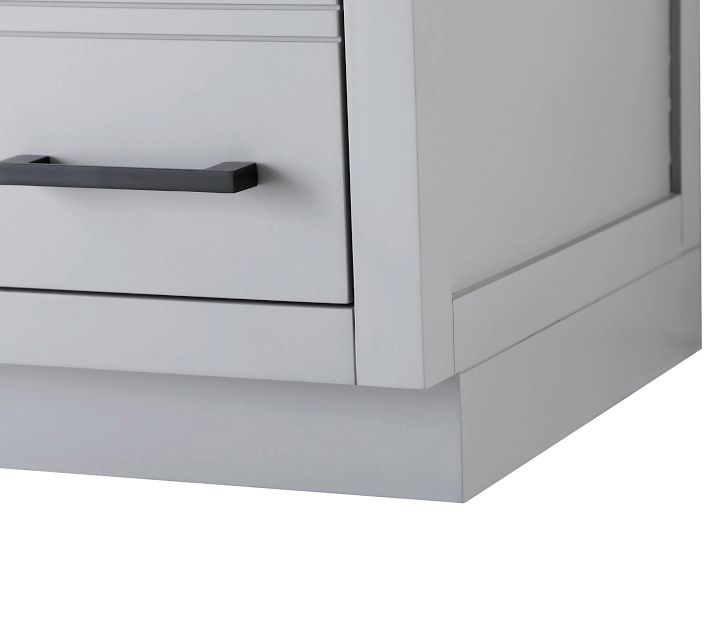 Bottom corner of a light gray bathroom cabinet showing a drawer with black handle.