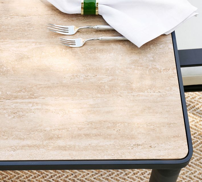 Close-up of two forks on a beige tabletop with napkin