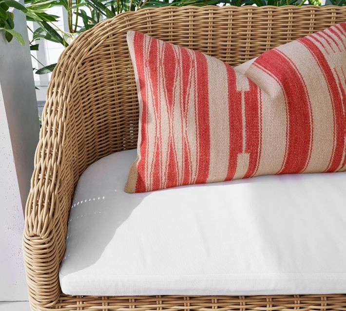 Close-up of red and white striped pillow on wicker chair