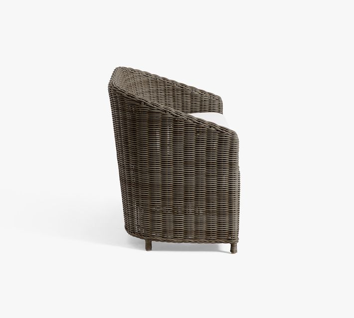 Brown wicker chair side view with white cushion
