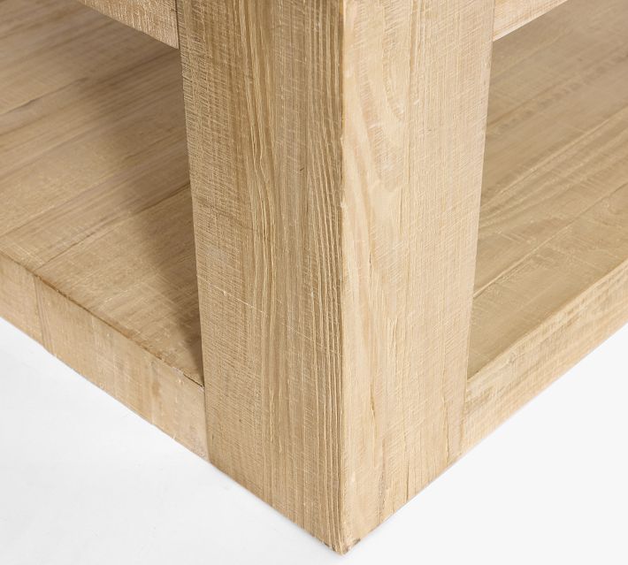 Close-up of thick wooden leg and joinery of a light wood coffee table.