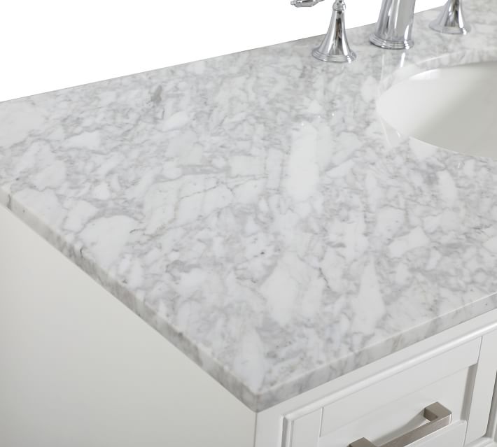 Close-up of cabinet edge and drawer fronts on white vanity, showing silver hardware