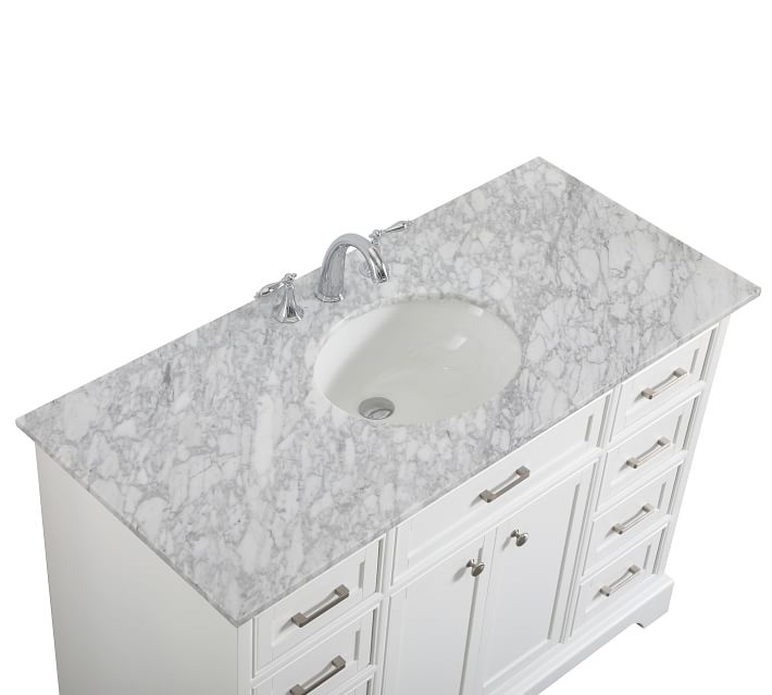Close-up of marble countertop with integrated sink and faucet holes, showing marble pattern and edge