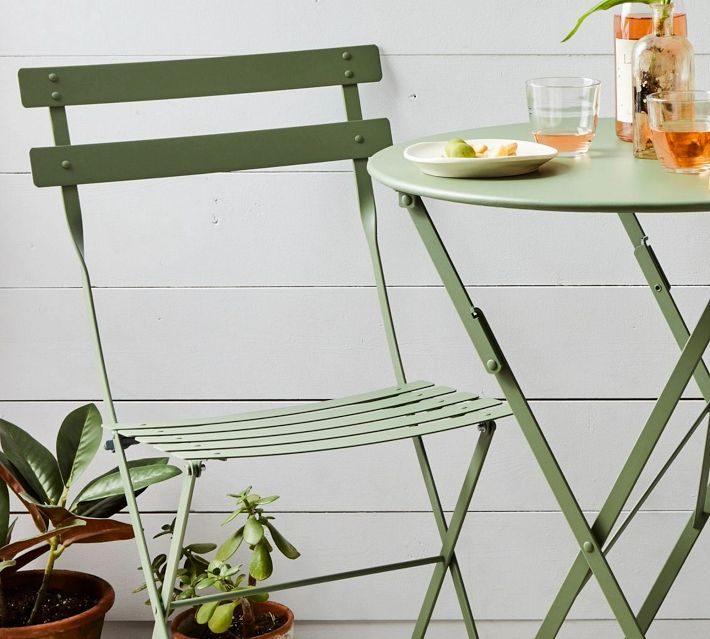 Light green round table and matching folding chair set on patio