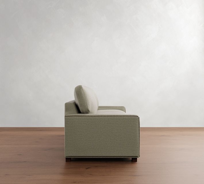 A side profile of a small beige loveseat with single arm, showcasing its compact depth.