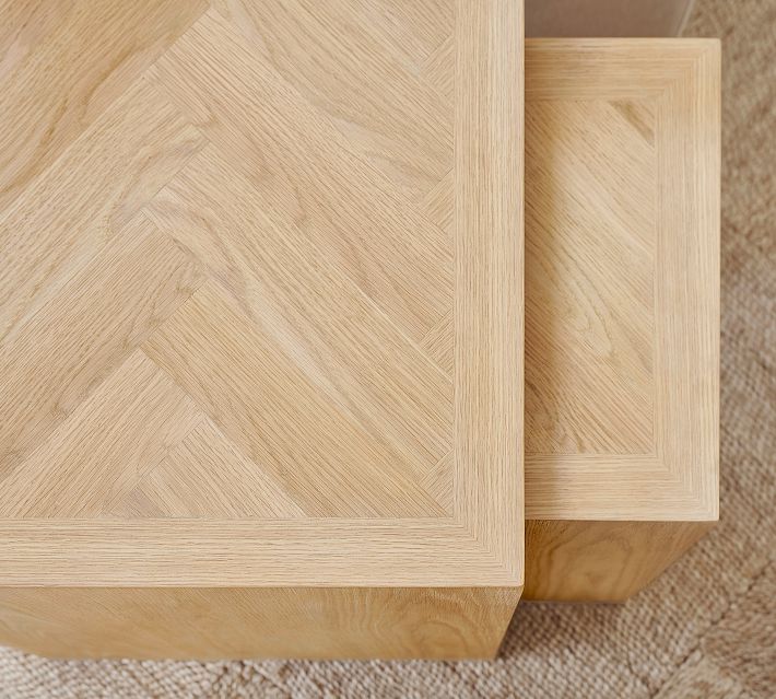 Close-up of the corner edge and parquet wood grain of a light wood table, showing joint construction.