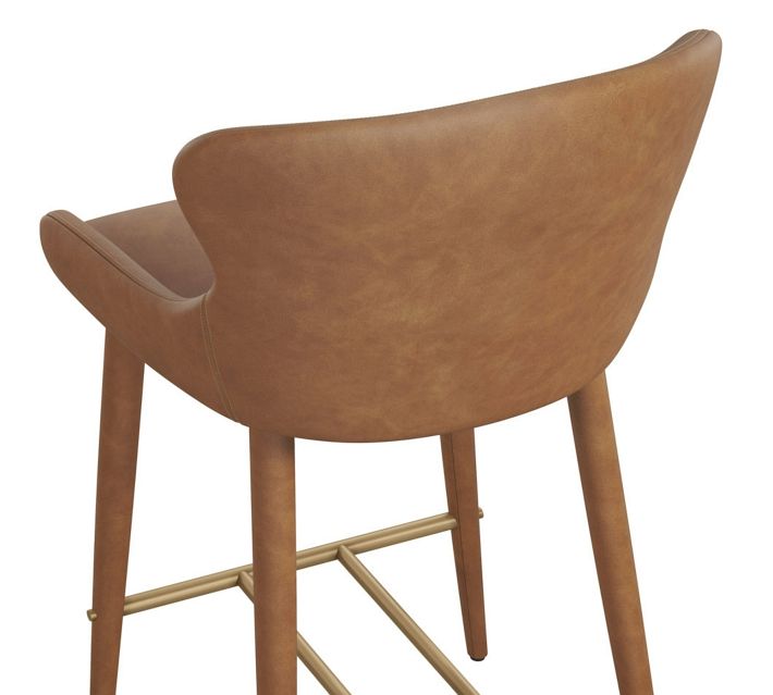 Close-up rear angle of a caramel brown upholstered bar chair, focusing on the curved back and side panel.